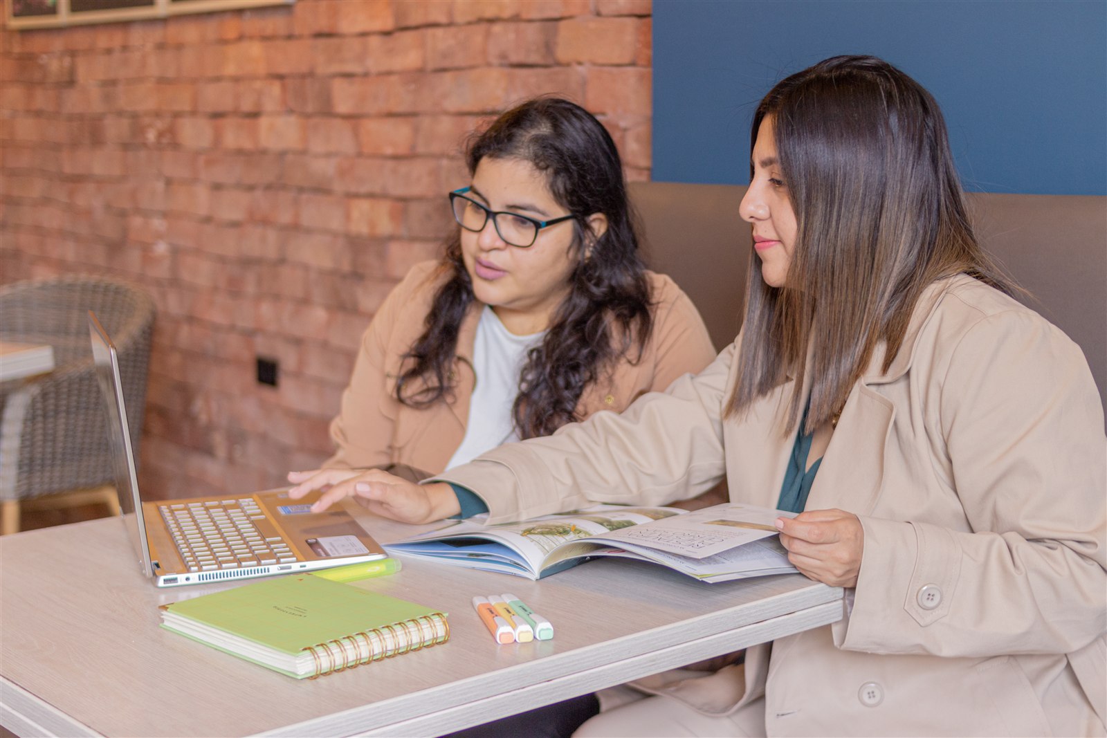 Equipo desarrollando propuesta con laptop y referencias